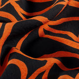 Ottoman viscose crêpe spaghetti orange print black background