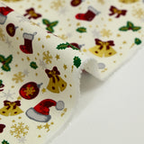 Cotton poplin printed with Santa's hats, socks and holly on an ecru background