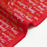 Cotton poplin printed with Merry Christmas in gold and silver on a red background