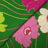 Viscose twill printed with anise and fuchsia flowers on a meadow green background