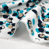 Satin de coton élasthanne dans les bulles turquoise fond blanc