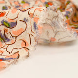 Viscose linen printed with blush and purple pansy flowers on an ecru background