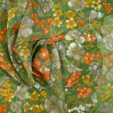Maille polyester lamée fleurs orange et vert fond vert prairie