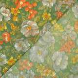 Maille polyester lamée fleurs orange et vert fond vert prairie