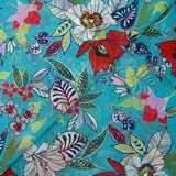 Muslin printed with exotic red and white flowers on a turquoise background