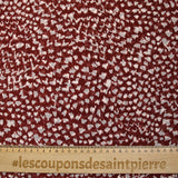 Mousseline imprimée taches animales fond bordeaux