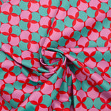 Popelín revestido estampado de lunares y trébol verde sobre fondo rojo