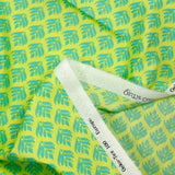 Coated poplin with turquoise vegetable print on lemon background