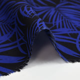 Viscosa estampada de hojas tropicales en azul royal con fondo negro
