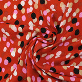 Viscose imprimée confettis noir, rose et beige fond rouge