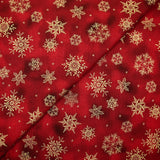 Popeline de coton imprimée flocons de neige dorés fond marbré rouge