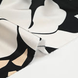 Raso de poliéster estampado fragmento beige y flor crudo fondo negro