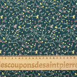 Cotton poplin printed with sprigs of mistletoe and gold stars on a green background