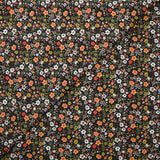 Digital printed cotton voile meadow of small green and orange flowers on a black background