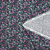 Cotton voile digitally printed meadow of small pink and water green flowers on a black background