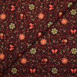 Cotton poplin printed with poinsettias and orange bows on a brown background