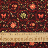 Cotton poplin printed with poinsettias and orange bows on a brown background