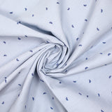 Popelina de algodón estampada con finas rayas azules y hojas azul marino