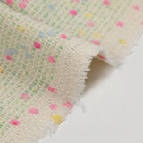 Tweed de laine mélangée confettis rose et bleu fond vert