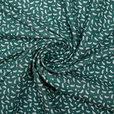 Cotton poplin printed with white twigs and stars on a green background