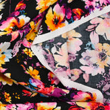 Viscose imprimée danse de fleurs rose et orange fond noir