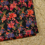 Maille de viscose satinée imprimée champs de fleurs corail fond noir