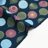 Cotton poplin printed with festive balls and golden sparkles on a navy blue background