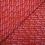 Cotton poplin printed with Merry Christmas in gold and silver on a red background