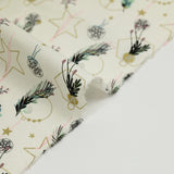 Cotton poplin printed with winter branches, golden balls and stars on an ecru background
