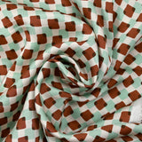 Viscose satin with brown and mint superimposed check print on an ecru background