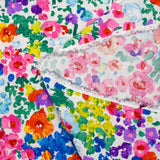 Crepon de viscosa lurex estampado flores rosas, verdes y amarillas sobre fondo blanco