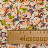 Viscose linen printed with blush and purple pansy flowers on an ecru background