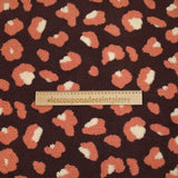 Salmon and ecru leopard faux sherpa fur, dark plum background