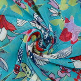 Muslin printed with exotic red and white flowers on a turquoise background