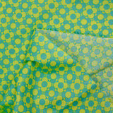 Coated poplin printed with fields of flowers, green lemon background