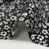 Viscose imprimée myriade de fleurs gris et blanc fond noir