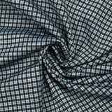 Punto Milano con cuadros azules y negros sobre fondo blanco.