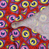 Coton imprimé ethnique Kampen rose et jaune fond rouge