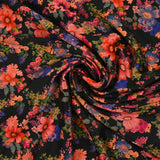 Maille de viscose satinée imprimée champs de fleurs corail fond noir