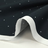 Cotton printed with mini polka dots on a midnight blue background