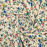 Punto de viscosa estampado con pequeñas flores campestres sobre fondo beige