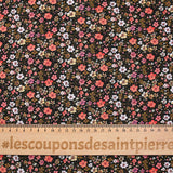 Digital printed cotton voile meadow of small orange and butter yellow flowers on a black background