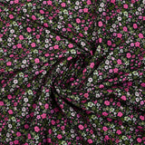 Digital printed cotton voile meadow of small fuchsia and apple green flowers on a black background