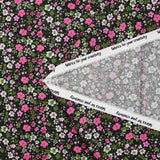 Digital printed cotton voile meadow of small fuchsia and apple green flowers on a black background
