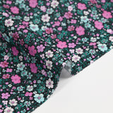 Cotton voile digitally printed meadow of small pink and water green flowers on a black background