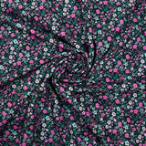 Cotton voile digitally printed meadow of small pink and water green flowers on a black background