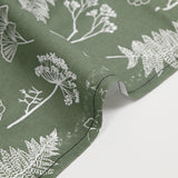 Cotton poplin printed with white botanical herbarium on a sage green background