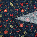 Cotton poplin printed with poinsettias and red bows on a navy blue background