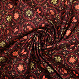 Cotton poplin printed with poinsettias and orange bows on a brown background