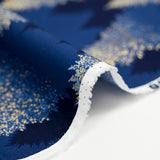 Cotton poplin printed with sparkling fir trees on a midnight blue background